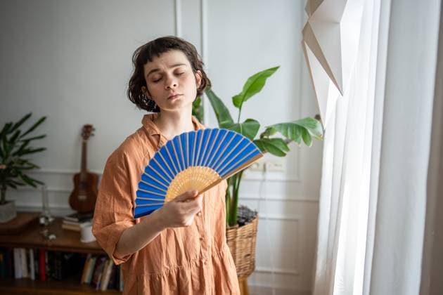 Creative Highlights Symbolbilder Traurige, müde Frau mit Ventilator, die den extremen Sommerbedingungen ausgesetzt ist. Hitzeerschöpfung und Frustration Sad exhausted woman using fan to cool down suffering from heat with broken AC, high temperature season. Heatwave impact, indoor discomfort, physical distress, urban struggle, health vulnerability (License=RF) ,model released, Symbolfoto Copyright: xZoonar.com DmitriixMarchenkox 23824675 ,model released, Symbolfoto ,property released