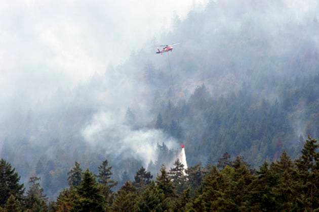 August 3, 2025, Coombs, Bc, CAN: A helicopter drops a bucket of water near Cameron Lake off Highway 4 where Wesley Ridge wildfire continues to burn out-of-control near Coombs, B.C., on Sunday, August 3, 2025. Coombs CAN  - ZUMAc35_ 20250803_zaf_c35_122 Copyright: xChadxHipolitox
