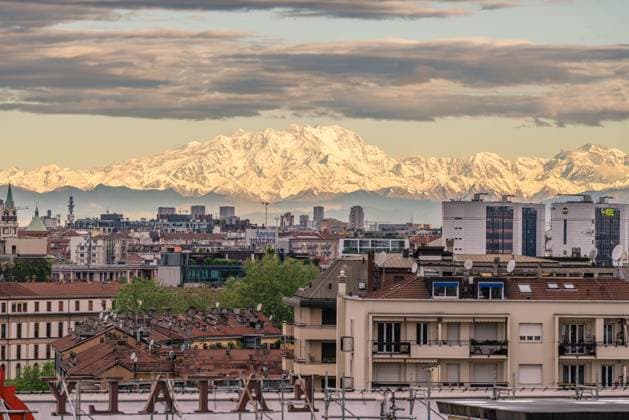 Panoramic view of Milan with the urban skyline in the foreground and a majestic snow-covered mountain in the background, symbolizing the visual connection between city and nature. Milan (Italy), April 24th, 2025 Milan Italy - ZUMAesty 20250424_aac_m169_095 Copyright: xDimitarxHarizanovx