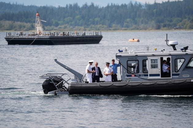 August 4, 2025, Nanoose Bay, Bc, CANADA: Prime Minister Mark Carney talks with Royal Canadian Navy Commander, Vice-Admiral Angus Topshee, left, and Commanding Officer of the CFMETR Craig Piccolo, front right, as they arrive on a boat to tour the Canadian Forces Maritime Experimental and Test Ranges (CFMETR), in Nanoose Bay, B.C.,, on Monday, August 4, 2025. Nanoose Bay CANADA - ZUMAc35_ 20250804_zaf_c35_042 Copyright: xDarrylxDyckx