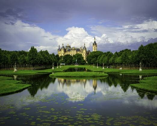 Ein Schloss bzw der Landtag spiegelt sich im Kreuzkanal des Schlossparks, umgeben von einer wunderschönen Parklandschaft und dramatischen Wolken in 19061 Schwerin A castle or the state parliament is reflected in the cross canal of the castle park, surrounded by a beautiful park landscape and dramatic clouds in 19061 Schwerin Copyright: imageBROKER FrankxNiehaus ibxfni14543775.jpg