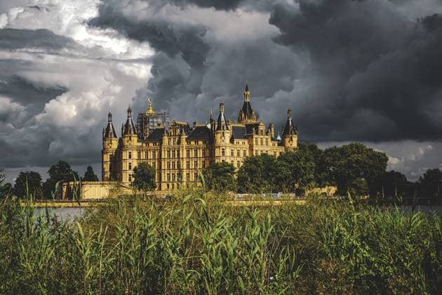 Ein majestätisches Schloss vor einem dramatisch bewölkten Himmel, umgeben von Wasser und Schilf. Ehemaliges Schloss und jetzt Museum sowie Landtag der Landeshauptstadt Schwerin (PLZ19061) A majestic castle against a dramatically cloudy sky, surrounded by water and reeds. Former castle and now museum and state parliament of the state capital Schwerin (postcode 19061) Copyright: imageBROKER FrankxNiehaus ibxfni14543779.jpg