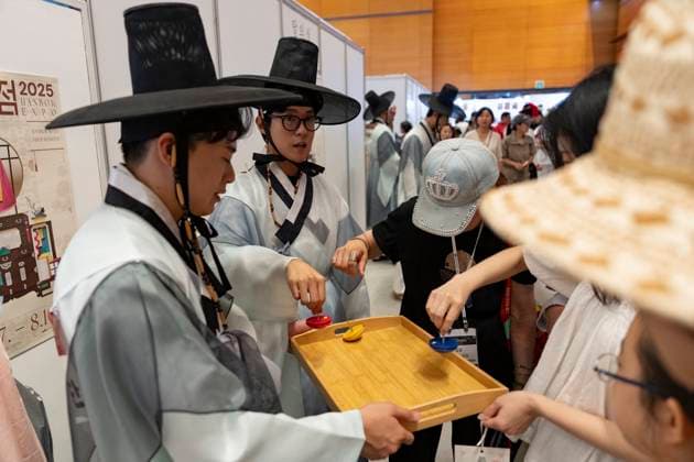 Visitors Attend 2025 Hanbok Expo At COEX In Seoul Visitors spin traditional Korean tops during the 2025 Hanbok Expo at COEX in Gangnam District, Seoul, South Korea, on August 7, 2025. The event, hosted by the Ministry of Culture, Sports and Tourism and organized by the Korea Craft & Design Foundation, is South Korea s only hanbok-dedicated trade fair and features 150 companies from both Korea and abroad. It continues through August 10. Seoul Seoul South Korea  Copyright: xChrisxJungx originalFilename: jung-visitors250807_npukl.jpg