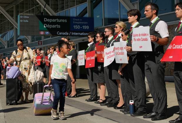 250811 -- VANCOUVER, Aug. 11, 2025 -- Passengers with luggage walk past Air Canada flight attendants standing in a silent protest at Vancouver International Airport during a national day of action in Richmond, British Columbia, Canada, on Aug. 11, 2025. Photo by Xinhua CANADA-VANCOUVER-FLIGHT ATTENDANTS-PROTEST LiangxSen  CANADA-VANCOUVER-FLIGHT ATTENDANTS-PROTEST IMAGO LiangxSen  imago images 1065045544