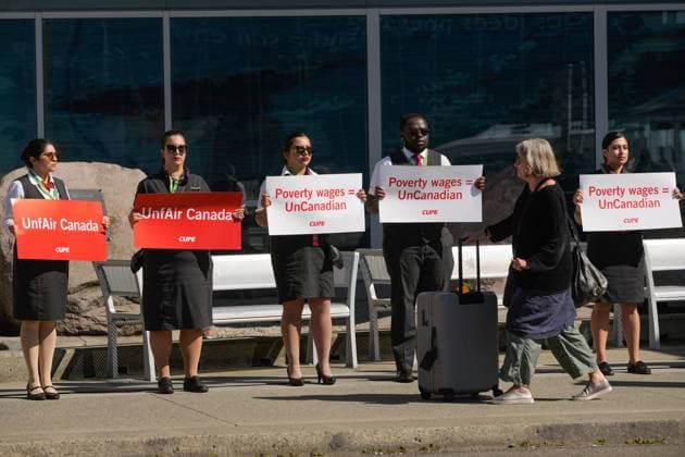 250811 -- VANCOUVER, Aug. 11, 2025 -- A passenger with luggage walks past Air Canada flight attendants standing in a silent protest at Vancouver International Airport during a national day of action in Richmond, British Columbia, Canada, on Aug. 11, 2025. Photo by Xinhua CANADA-VANCOUVER-FLIGHT ATTENDANTS-PROTEST LiangxSen  CANADA-VANCOUVER-FLIGHT ATTENDANTS-PROTEST IMAGO LiangxSen  imago images 1065045547