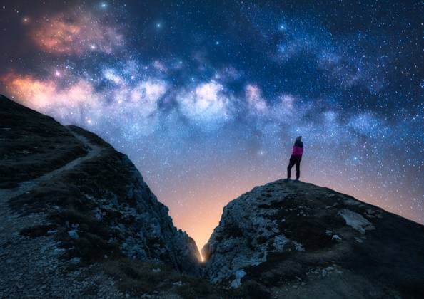 Creative Highlights Symbolbilder Glowing Milky Way and woman on mountain peak at starry night. Dolomites, Italy. Galaxy. Space landscape with silhouette of a girl, trail, rocks, sky with bright stars. Milky Way and hiker. Nightscape Model Released DenisBilytskyi_ID30243_1019589_014 Copyright: xx