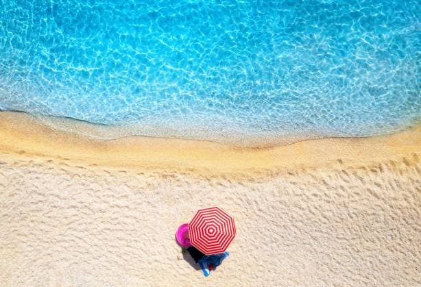 Creative Highlights Symbolbilder Aerial view of red umbrella, sandy beach, blue sea, waves at sunset in summer. Tropical landscape with seashore, clear turquoise water. Top view from drone. Lefkada island, Greece. Travel Model Released DenisBilytskyi_ID30691_1038752_007 Copyright: xx