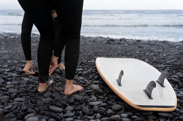 Creative Highlights Symbolbilder Surfers putting on leashes on a volcanic beach getting ready to surf Two surfers are putting on their leashes on a black volcanic beach with their surfboard lying on the pebbles, getting ready for a surf session Model Released MiguelSerrano_ID30324_1023684_022 Copyright: xx