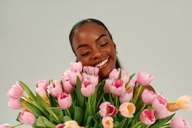 Creative Highlights Symbolbilder Smiling African American woman holding bouquet of tulips for Mothers Day or Womens Day African American woman holding pink tulip bouquet, celebrating Mother Day or Women Day with joy and love, smiling brightly on neutral background. Concept of spring holidays and feminine beauty. Model Released OrionProduction_ID30910_1048074_022 Copyright: xx