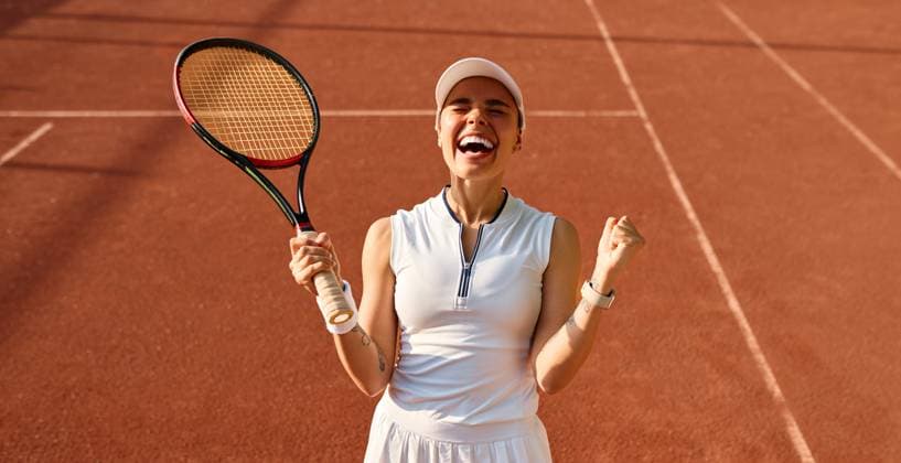 Creative Highlights Symbolbilder Joyful female tennis player celebrating on court Excited woman with tennis racket smiling and raising her fists in joy after a win. Concept: success, happiness, sport victory, female empowerment, celebration. Model Released OrionProduction_ID30915_1048409_032 Copyright: xx