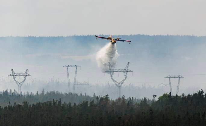 August 14, 2025, St. John s, Nl, CANADA: A water bomber provides a steady steam of water to assist crews on the ground at the Paddy s Pond wildfire, just outside St. John s, N.L., on Thursday, Aug. 14, 2025. St. John s CANADA  - ZUMAc35_ 20250814_zaf_c35_076 Copyright: xPaulxDalyx