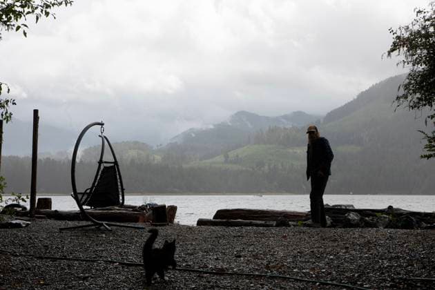August 16, 2025, Port Alberni, Bc, CAN: A Macktush Creek Campsite host whistles over a young cat as smoke and fog mix with the Underwood Mountain wildfire across the Alberni Inlet south of Port Alberni, B.C., on Saturday, August 16, 2025. Port Alberni CAN  - ZUMAc35_ 20250816_zaf_c35_132 Copyright: xChadxHipolitox
