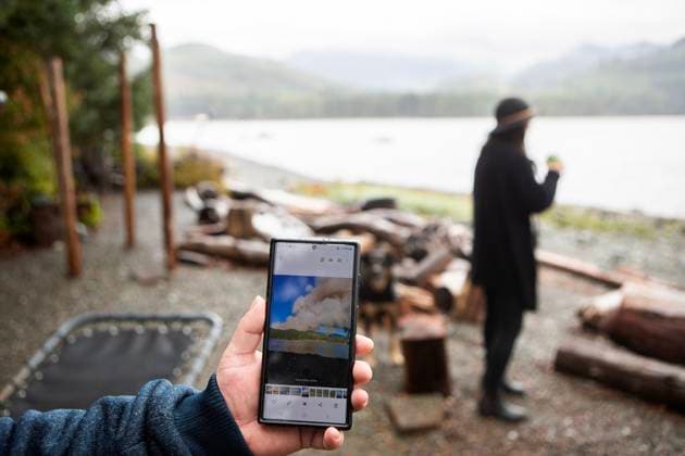 August 16, 2025, Port Alberni, Bc, CAN: Troy Schmitz holds a picture he took last Monday when the Underwood Mountain wildfire first broke out from across the Alberni Inlet while staying at the Macktush Creek Campsite off Canal Main Rd. south of Port Alberni, B.C., on Saturday, August 16, 2025. Port Alberni CAN  - ZUMAc35_ 20250816_zaf_c35_133 Copyright: xChadxHipolitox