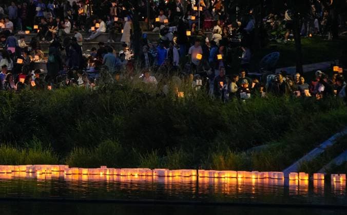 (250817) -- COQUITLAM, Aug. 17, 2025 -- People participate in the Water Lantern Festival at Lafarge Lake in Coquitlam, British Columbia, Canada, Aug. 16, 2025. The event attracted hundreds of residents and visitors to enjoy the illuminated lanterns and share wishes for hope and joy. (Photo by Xinhua) CANADA-COQUITLAM-WATER LANTERN FESTIVAL LiangxSen 