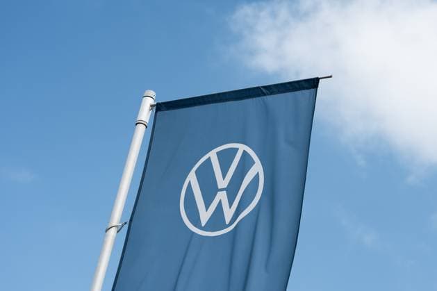 Das Logo des Deutschen Automobilherstellers Volkswagen ist vor einem VW Autohaus auf einer Flagge zu sehen. Rottweil Baden-Württemberg Deutschland *** The logo of the German car manufacturer Volkswagen can be seen on a flag in front of a VW dealership Rottweil Baden Württemberg Germany