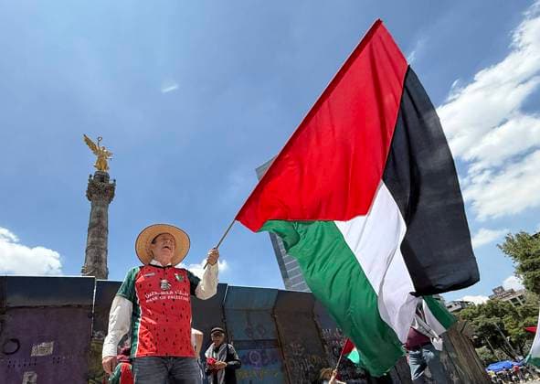 250818 -- MEXICO CITY, Aug. 18, 2025 -- This photo taken with a mobile phone shows a protester waving the Palestinian flag to protest the ongoing war and famine in Gaza at the monument, the Angel of Independence, in Mexico City, Mexico, on Aug. 17, 2025. MEXICO-MEXICO CITY-GAZA-PROTEST WuxWei  MEXICO-MEXICO CITY-GAZA-PROTEST IMAGO WuxWei  imago images 1065275073