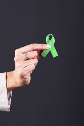Die Hand einer Frau hält eine grüne Schleife, ein Symbol für psychische Gesundheit, Depression und Organspende Woman s hand holding a green ribbon, symbol of mental health awareness, depression, and organ donation Copyright: imageBROKER ValeriaxVenezia ibxvve14653614.jpg