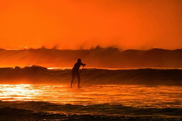 August 19, 2025, Isle Of Palms, South Carolina, USA: A paddle surfer silhouetted by the sunrise heads out to catch a wave on Front Beach, August 19, 2025 in Isle of Palms, South Carolina. High waves and dangerous rip-tides are effecting the region as Hurricane Erin, a category 2 storm passes off the coast. Isle Of Palms USA - ZUMAe02_ 20250819_new_e02_137 Copyright: xRichardxEllisx
