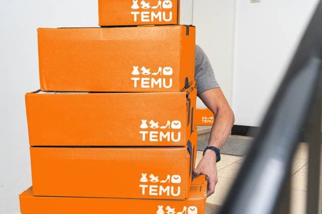 Bavaria, Germany - August 21, 2025: Photo montage, several orange Temu packages are delivered and stacked in the stairwell. The image shows the impact of online retail, shipping, and e-commerce on everyday life and parcel logistics. *** Fotomontage, Mehrere orangefarbene Temu-Pakete werden geliefert und im Treppenhaus gestapelt. Das Bild zeigt den Einfluss von Onlinehandel, Versand und E-Commerce auf den Alltag und die Paketlogistik.