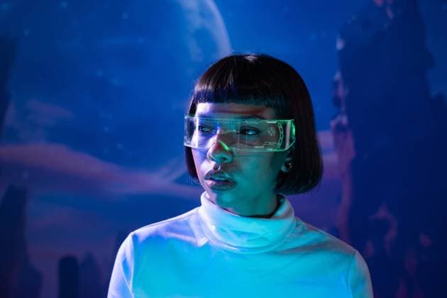 IMAGO Creative, Lifestyle, Gaming MR_ID31144_22470_OrianaDiaz.jpg A Latin woman, wearing futuristic virtual reality glasses, is immersed in a technological experience. The blue ethereal background enhances the sense of advanced digital interaction. Model Released ManuelRuiz_ID31144_1056386_005 Copyright: xManuelxRuizx