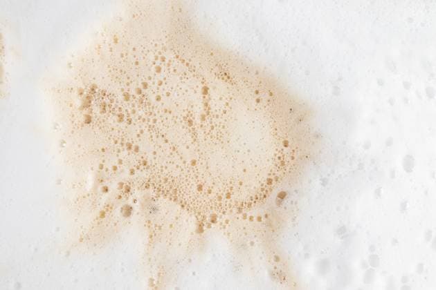 Macro view of frothy coffee foam texture against white Close-up macro shot of frothy coffee foam showcasing its intricate texture. The light beige foam rests against a white background, illustrating bubbles and surface detail. Model Released MarinaMos_ID30587_1034052_007 Copyright: xMarinaxMosx