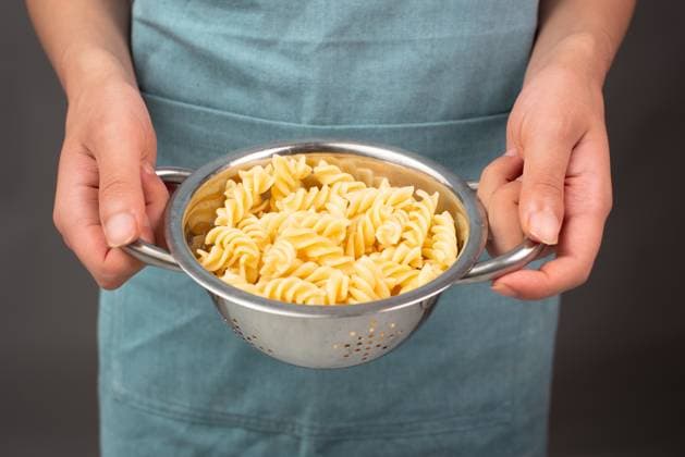 Gekochte Fusilli-Nudeln in einem Sieb, italienische Lebensmittelzutaten, Hände mit Sieb *** cooked Fusilli Noodles in a Sieve, Italian Food ingredients, Hands with Sieve 1133602755