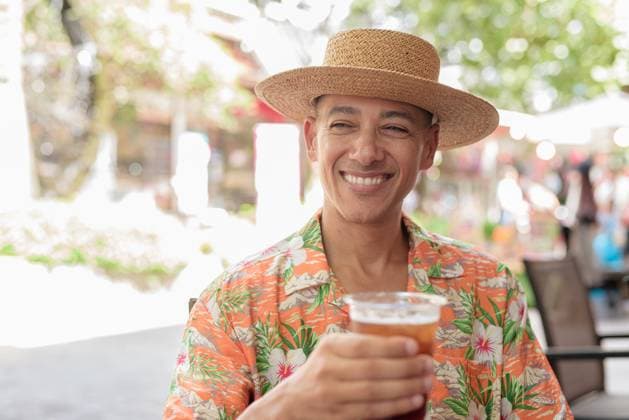 IMAGO Creative, Food, Trend, Iced Coffee Hispanischer Mann mit Eiskaffee in einem Straßencafé, der einen Panamahut und ein kurzärmeliges Hemd trägt A Hispanic male tourist enjoying an iced coffee while sitting at an outdoor cafe on a sunny day, wearing a Panama hat and short sleeve shirt. Casual summer beverage scene. (License=RF) ,model released, Symbolfoto Copyright: xZoonar.com TonixRantalax 23869773 ,model released, Symbolfoto ,property released