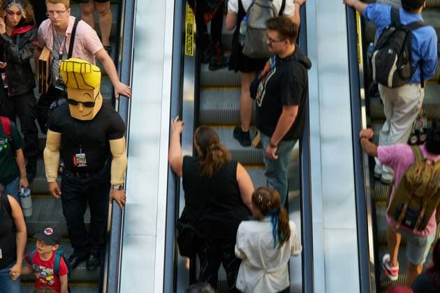 August 22, 2025, Toronto, On, Canada: A Convention-goer in a Johnny Bravo cosplay (left) makes their way down the escalators on the second day of the annual Fan Expo convention in Toronto, on Friday, Aug. 22, 2025. Toronto Canada  - ZUMAc35_ 20250822_zaf_c35_150 Copyright: xSammyxKoganx