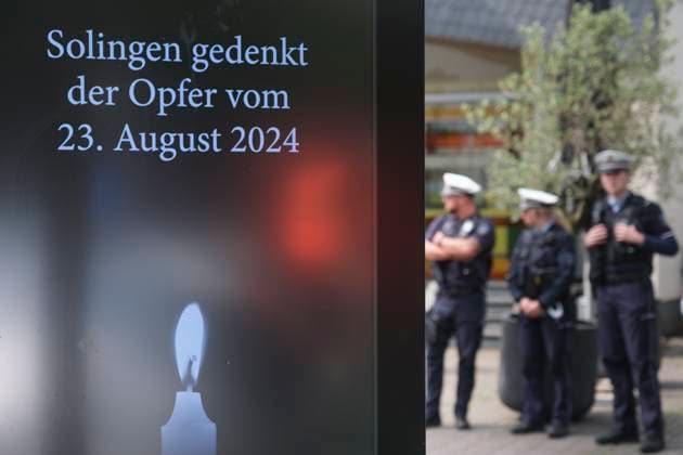 Ein Jahr nach dem terroristischen Anschlag in Solingen wird am Samstag (23.08.2025) der Opfer gedacht (Foto: Polizisten stehen neben einer digitalen Gedenktafel). Bei dem islamistisch motivierten Messeranschlag am 23. August 2024 hatte ein als Asylbewerber nach Deutschland gekommener Syrer Besucher des Solinger Stadtfestes zum 650-jaehrigen Bestehen angegriffen. Drei Menschen wurden durch Stiche getoetet und acht verletzt. Gegen den mutmasslichen Taeter Issa al H. laeuft derzeit der Prozess vor dem Oberlandesgericht Duesseldorf. Der Anschlag hatte eine intensive Debatte ueber die Asyl- und Fluechtlingspolitik ausgeloest. (Siehe epd-Meldungen vom 23.08.2025) EDITORIAL USE ONLY *** One year after the terrorist attack in Solingen, the victims Copyright: epd-bild GuidoxSchiefer 20250823-DSCF9787