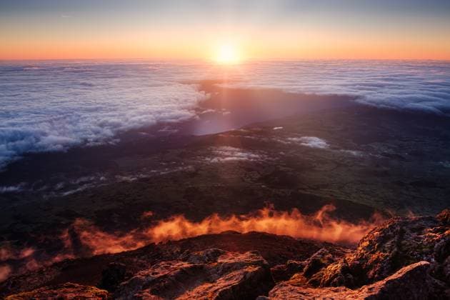 Creative Highlights World Scenic view of colorful sunrise over clouds, coastline and volcanic rocks on Mt Pico, Azores Scenic view of colorful sunrise over clouds, coastline and volcanic rocks on Mt Pico, Azores, Portugal, 64012454.jpg RECORD DATE NOT STATED