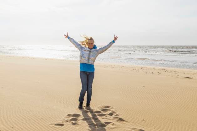 Creative Highlight Symbolbilder Woman cheering on a windy beach showing joy and freedom model released, Symbolfoto, GWF08351