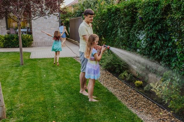 Family gardening together outdoors and watering plants in summer model released, Symbolfoto property released, MDOF02998