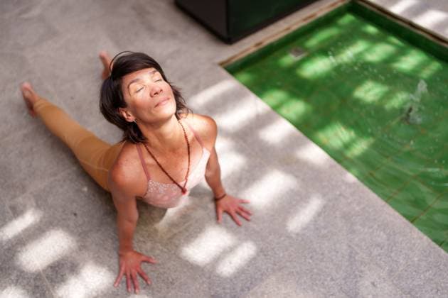 Creative Highlight Symbolbilder Woman practicing yoga on patio floor next to fountain in sunlight model released, Symbolfoto property released, JZF00061