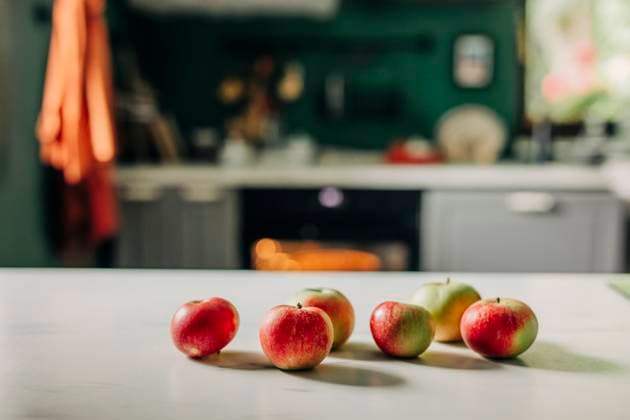Apples and dough on table in cozy country kitchen with oven baking property released, VSNF03889
