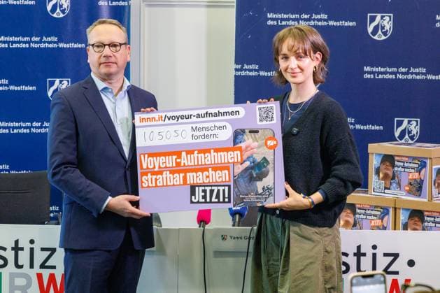 25.08.2025. Düsseldorf. NRW-Minister der Justiz Dr. Benjamin Limbach nimmt die Petition Voyeur-Aufnahmen strafbar machen von Yanni Gentsch entgegen, die online bereits über 80.000 Menschen unterzeichnet haben. Er will sich auf der kommenden Justizministerkonferenz für die Beseitigung der strafrechtlichen Schutzlücke einsetzen, wenn Bildaufnahmen aus sexueller Motivation heraus ohne oder gegen den Willen der Betroffenen hergestellt werden. Anlass ist der Fall der Kölner Joggerin Yanni Genstch, die im Februar 2025 von einer unbekannten männlichen Person beim Joggen mit dem Fokus auf ihr bekleidetes Gesäß aus mutmaßlich sexueller Motivation heimlich gefilmt worden war. Sie hat dies öffentlich gemacht und eine Online-Petition initiiert, die