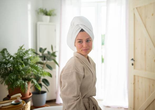 young woman enjoying hair care routine in cozy bathroom. young woman enjoying hair care routine in cozy bathroom. Self-care ritual. model released