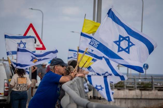 News Bilder des Tages August 26, 2025, Beit Yanai, Israel: An Israeli protestor holds the Israeli flag. Major highways across Israel were blocked as the families of hostages and missing families forum, along with anti-Netanyahu and anti-government groups, launched another day of protests demanding action for the Israeli hostages. Beit Yanai Israel - ZUMAs197 20250826_aaa_s197_022 Copyright: xEyalxwarshavskyx
