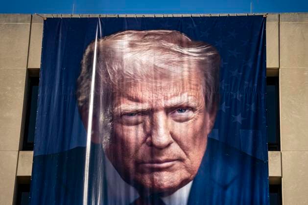 A portrait of President Donald Trump is draped on the front of the Department of Labor Headquarters in Washington, DC on Saturday, August 30, 2025. The banner, displayed next to a portrait of Teddy Roosevelt, features Trump s second inaugural portrait, the logo for his America 250 initiative, and the words American Workers First.  WAP20250830323 BONNIExCASH