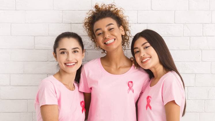Three Girls In T-Shirts With Ribbons Standing Over White Wall Breast Cancer Volunteers. Three Multiracial Girls In Pink T-Shirts With Ribbons Hugging Smiling To Camera Standing Over White Wall. Panorama, model released, , 61100268.jpg RECORD DATE NOT STATED
