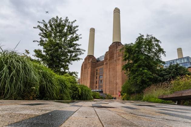 Battersea Power Station with Modern Landscape and Greenery on a Cloudy Day A low angle view of Battersea Power Station, surrounded by greenery and a modern walkway, 65020746.jpg RECORD DATE NOT STATED
