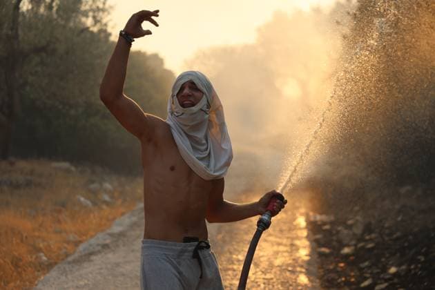 News Themen der Woche KW36 Wild fire on the Greek island of Lesbos LESBOS, GREECE - SEPTEMBER 04: A man covers his face with his t-shirt to protect himself from the smoke spraying water with a hose as teams and local residents continue their efforts to extinguish the fire that broke out next to Vrisa village of Lesbos, Greece on September 04, 2025. Stringer Anadolu Lesbos Greece. Editorial use only. Please get in touch for any other usage.  Copyright: x2025xAnadoluxStringerx