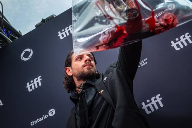 September 5, 2025, Toronto, On, Canada: Karim Daoud Anaya holds up a camera soaked in fake blood on the red carpet for öÄuPalestine 36öÄÃ¹ at the Toronto International Film Festival in Toronto on Friday, September 5, 2025. Toronto Canada  - ZUMAc35_ 20250905_zaf_c35_044 Copyright: xLauraxProctorx