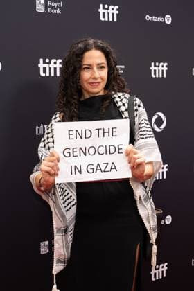 September 5, 2025, Toronto, Ontario, Canada: A guest holds a banner reading End the Genocide in Gaza during the red carpet for the Palestine 36 premiere during the 2025 Toronto International Film Festival at Roy Thomson Hall. on September 5, 2025 in Toronto, Canada. Toronto Canada - ZUMAe321 20250905_zea_e321_032 Copyright: xLeonardoxRamirezx