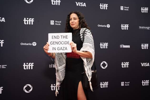 September 5, 2025, Toronto, Ontario, Canada: A guest holds a banner reading End the Genocide in Gaza during the red carpet for the Palestine 36 premiere during the 2025 Toronto International Film Festival at Roy Thomson Hall. on September 5, 2025 in Toronto, Canada. Toronto Canada - ZUMAe321 20250905_zea_e321_090 Copyright: xLeonardoxRamirezx