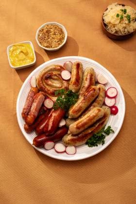 Traditional German sausage platter with sauerkraut Top view of a traditional German platter featuring assorted grilled sausages including Bratwurst and Frankfurters, served with tangy sauerkraut and mustard on an autumn table. Model Released MariaShchipakina_ID30874_1046500_008 Copyright: xMariaxShchipakinax RECORD DATE NOT STATED