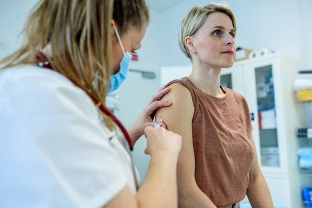 Doctor administering vaccine to woman s arm during routine immunization Doctor administering vaccine to woman s arm during routine immunization. Disease prevention. model released