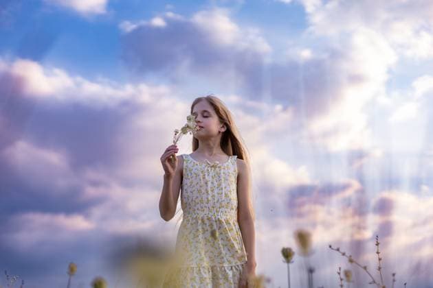 Creative Highlight Symbolbilder Girl Smelling Wildflowers Under Sky CR_UUAB250907-1825228-01 ,model released, Symbolfoto