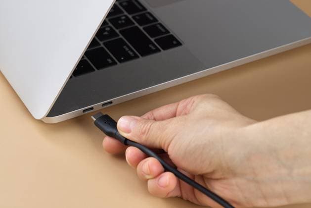 female hand connecting charger cable to laptop female hand connecting charger cable to laptop at beige background, closeup, 97011644.jpg RECORD DATE NOT STATED