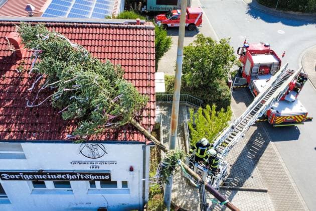 News Bilder des Tages Der Berkacher Kerwebaum fiel zum Glück erst nach Ende der Kerb auf das Dach des Dorfgemeinschaftshauses und musste von Bauhof und Feuerwehr geborgen werden - Berkach 11.09.2025: Kerwebaum fällt aufs Dorfgemeinschaftshaus *** Fortunately, the Berkach parish fair tree only fell onto the roof of the village community center after the end of the parish fair and had to be rescued by the building yard and fire department Berkach 11 09 2025 Parish fair tree falls onto the village community center