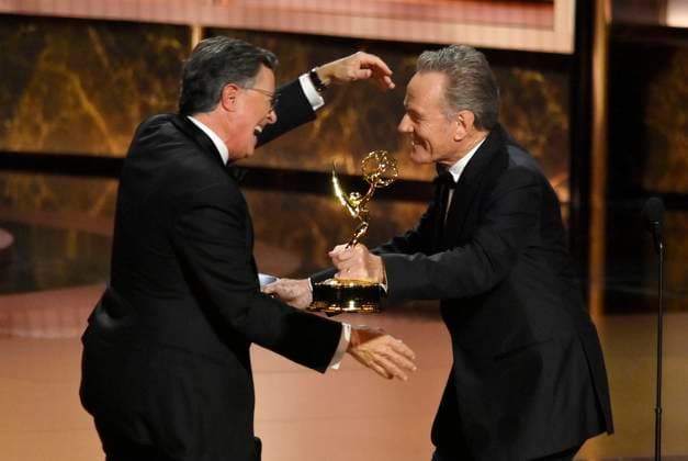 Bryan Cranston hands Stephen Colbert the Outstanding Talk Series Award for The Late Show with Stephen Colbert onstage at the 77th annual Primetime Emmy Awards at the Peacock Theater in Los Angeles on Sunday, September 14, 2025.  LAP2025091430717 JIMxRUYMEN
